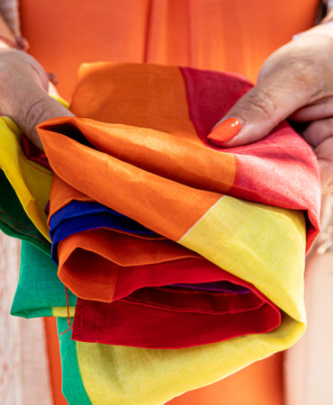 Close up of a mature woman holding an LGBT rainbow flag. Gay parade, freedom, toleranceの写真素材