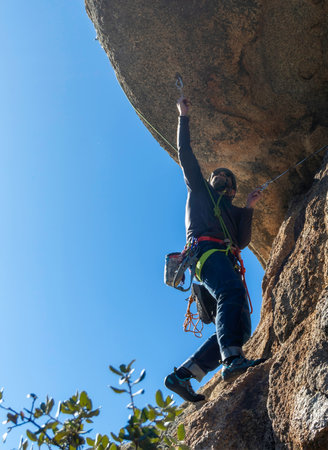 Young adult climbing a granite overhang at Torrelodones, Madrid. Rock climbing. Extreme sports conceptの写真素材