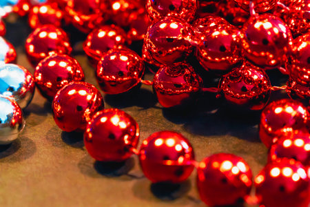 Garlands of red metallic pearls on a wooden table. Christmas decoration. Close up. Selective focusの写真素材