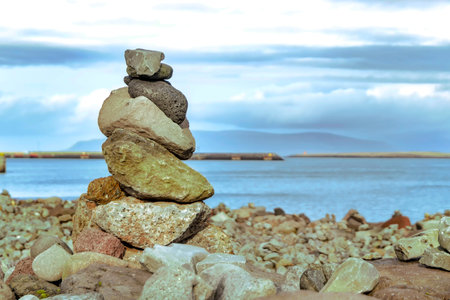 Creative artwork of balancing of coarse rough uneven different colored stones placed one on another...