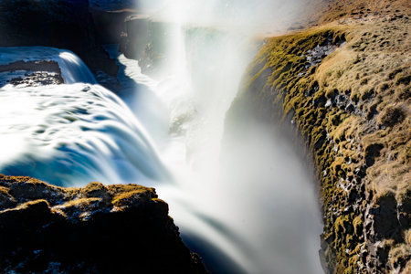 From above powerful and foamy waterfall turning into raising vapor in atmospheric pressure while...