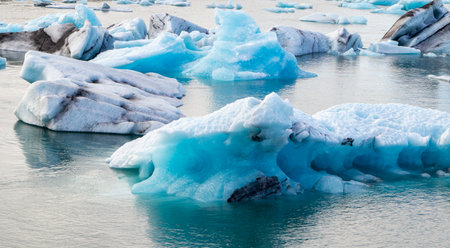 A large body of water with ice floating on top. The ice is blue and white. The water is calm and...