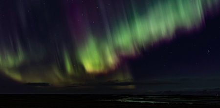 The sky is filled with a beautiful display of auroras. The colors are vibrant and the sky is darkの写真素材