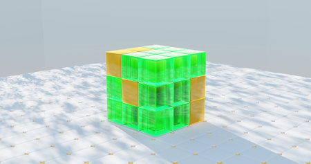 A green cube made of smaller cubes in green and orange is sitting on a white surface. The cube is made of clear glass and has a unique design. The image has a bright and cheerful moodの写真素材