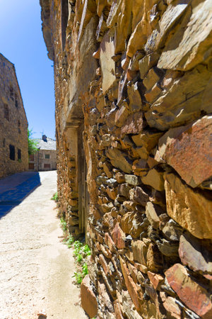 A stone wall with a door in the middle. The wall is made with slate stones. Typical architecture of...