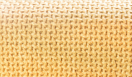 Detailed texture of tightly woven jute or cotton material in warm golden-brown tones. Excellent...