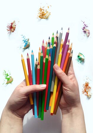 Hold color pencils in hands. Rainbow watercolor pencils.の写真素材