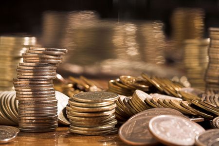 Set of coins on a table with a curve mirror, (studio, halogen light).