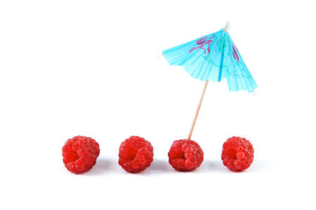 A row of Raspberries with a blue cocktail umbrella isolated on a white backgroundの写真素材