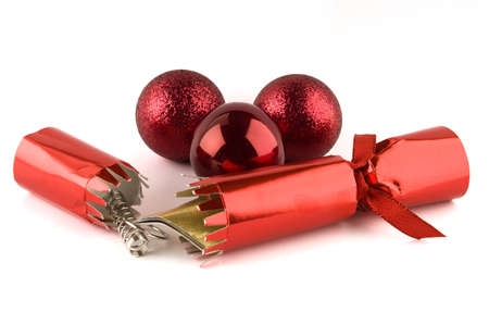 Red Christmas cracker that has been opened and red baubles isolated on a white backgroundの写真素材