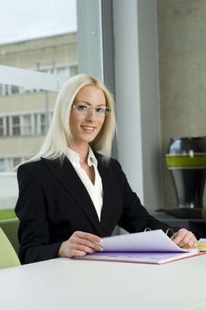 Blonde business woman working at deskの写真素材