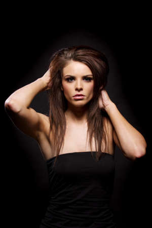 Gorgeous brunette woman looking at the camera on a black backgroundの写真素材