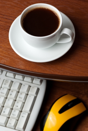 Coffee on computer desk. Keyboard and mouseの写真素材