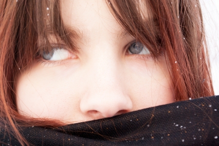Sad girl in a black headscarf in the winter in the streetの写真素材
