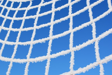 Net of goal in hoarfrost on blue skyの写真素材