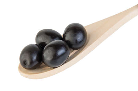 Black olives in wooden spoon isolated on white backgroundの写真素材
