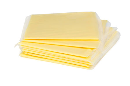 Square pieces of cheese in plastic packagingisolated on white backgroundの写真素材