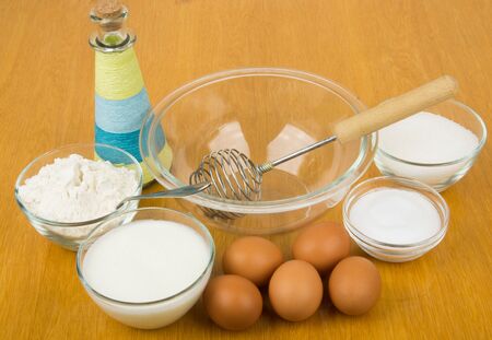 Flour, salt, sugar, flour, eggs, oil bottle and utensils for cooking doughの写真素材