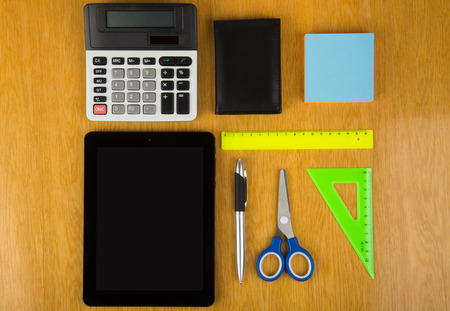 Calculator, tablet PC and stationery on tableの写真素材