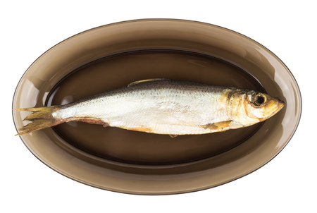 One herring in black transparent glass plate isolated on white backgroundの写真素材