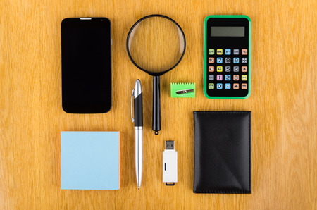 Set of office tools, modern smartphone and flashcard on wooden table