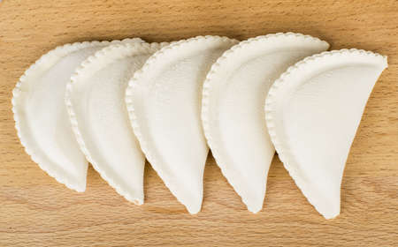 Five frozen chebureks on beech wooden boardの写真素材