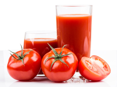 Tomatoes  and juice in glass on white backgroundの写真素材