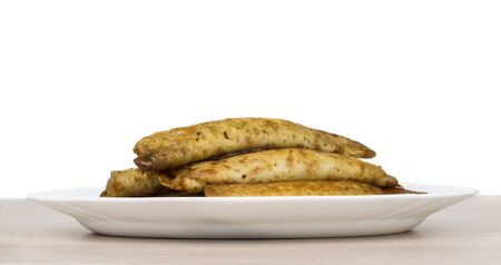 Pancake stuffed in white dish on wooden table, side view