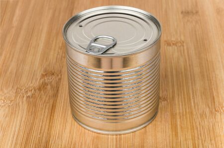 Closed metal cans with ring on wooden bamboo board