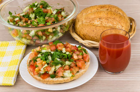 Bread with vegetables tomato juice loaf of bread and salad in bowl