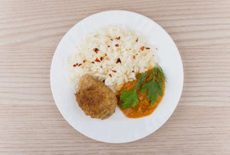 Fried cutlet with rice squash caviar and greens on table. Top viewの写真素材