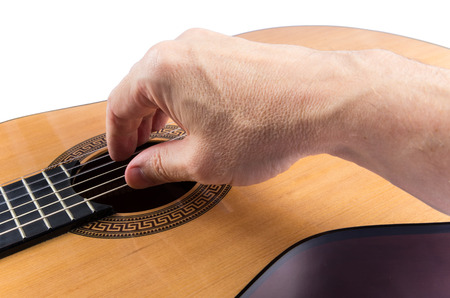 Man's hand on strings of classical guitar isolated on white backgroundの写真素材