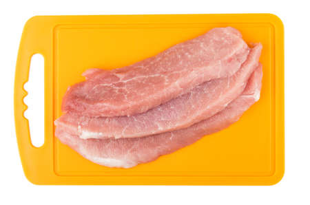 Pieces of raw pork on plastic board isolated on white backgroundの写真素材