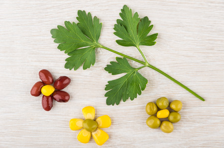 Flowers from green peas, beans, sweet corn, parsley on wooden tableの写真素材