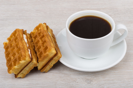 Black coffee and viennese waffles on wooden tableの写真素材