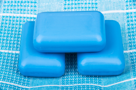 Three pieces of blue soap on checkered towelの写真素材