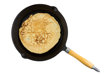 Single russian pancake in frying pan with wooden handle isolated on white backgroundの写真素材