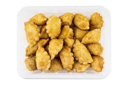 Plastic box with frozen small chebureks isolated on white background