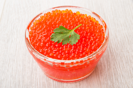 Imitation red caviar from seaweed in transparent bowl on wooden tableの写真素材