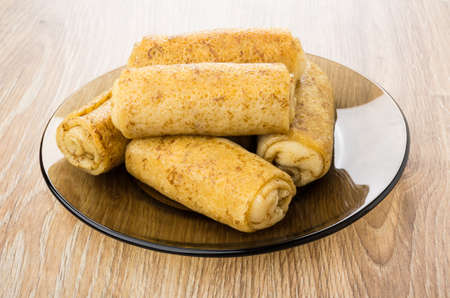 Heap of pancake stuffed in brown transparent plate on wooden table