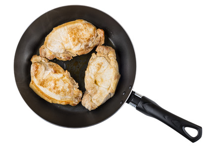 Three fried pork cutlets in frying pan isolated on white background. Top viewの写真素材