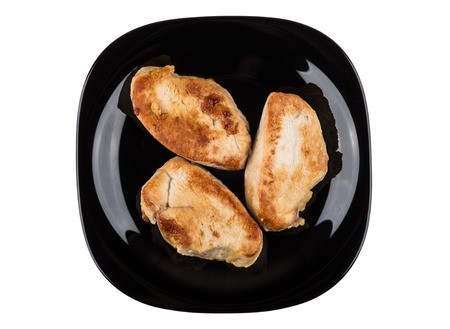 Pieces of fried turkey meat in black plate isolated on white background. Top viewの写真素材