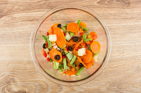 Transparent glass bowl with vegetable mix on wooden table. Top viewの写真素材