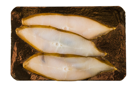 Slices of smoked halibut on goldish cardboard isolated on white background. Top view