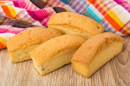 Cookies in form small loaf and checkered napkin on wooden tableの写真素材