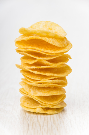 Stack of potato chips on wooden tableの写真素材