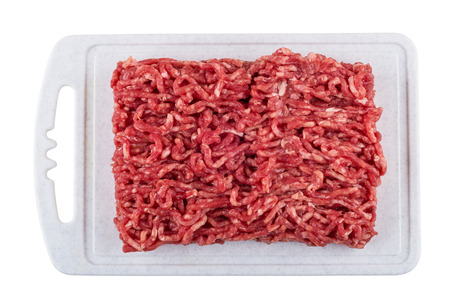 Beef mince on plastic cutting board isolated on white background. Top view