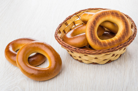 Bread rings in wicker basket and on wooden table