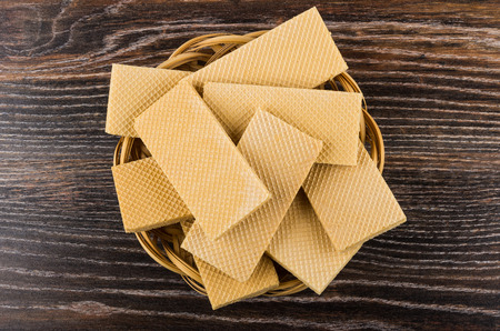 Heap of wafers in wicker basket on dark wooden table. Top viewの写真素材