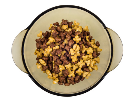 Brown glass bowl with breakfast cereals in form stars isolated on white background. Top view